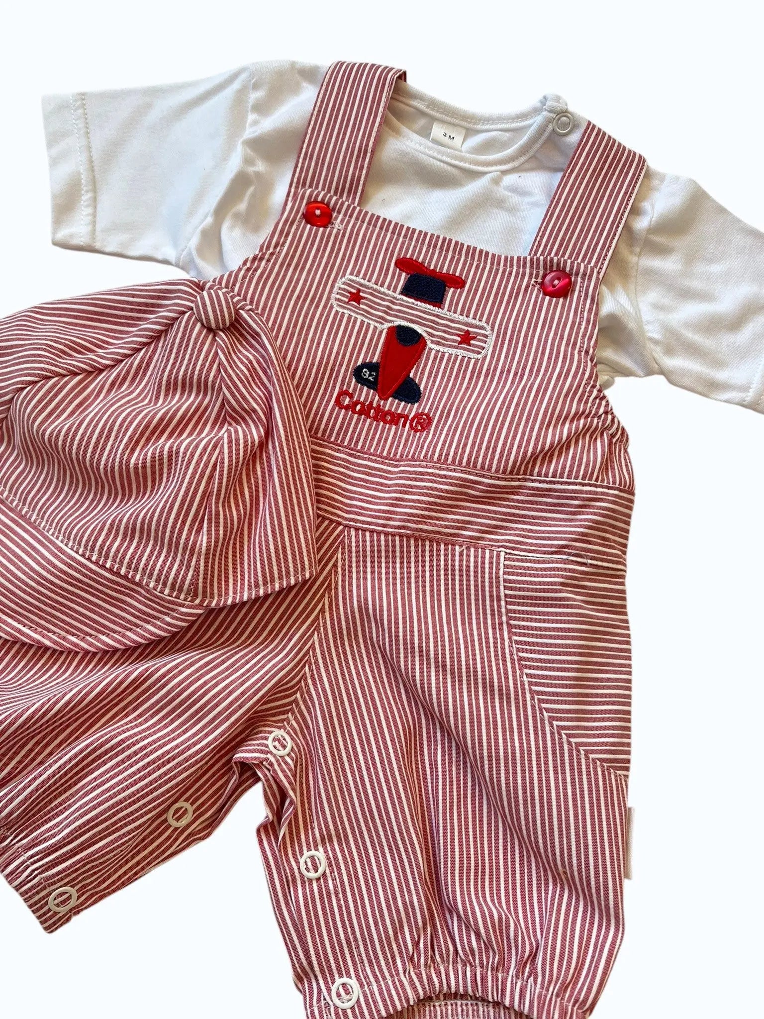 jardineira de bebe em vermelho e branco com ilustração de avião 